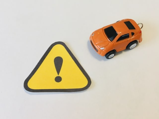 感嘆符とオレンジ色の車の模型