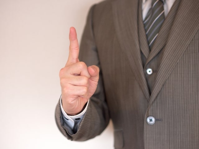 人差し指を立てる男性